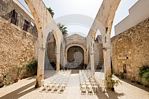 Church roofless for weddings with white chairs.