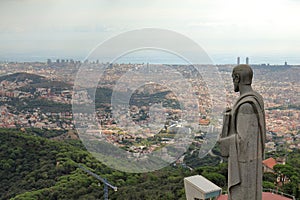 Apostle sculpture of The Sacred Heart of Jesus Church looks on Barcelona City, Mount Tibidabo, Barcelona, Catalonia, Spain photo