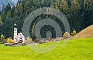 The church of Saint John, Ranui, Chiesetta di san giovanni in Ranui Runes South Tyrol Italy, surrounded by green meadow, forest