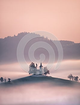 Church of Saint Tomas, Slovenia emerging from fog photo