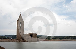 Church of Sant Roma de Sau in the Sau reservoir with silk effect water with people