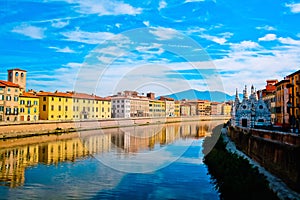 Church Santa Maria della Spina on the Arno river embankment in Pisa with colorful old houses, Italy, Europe. photo