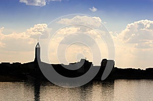 Church silhouette over the blue sky and on a lake side