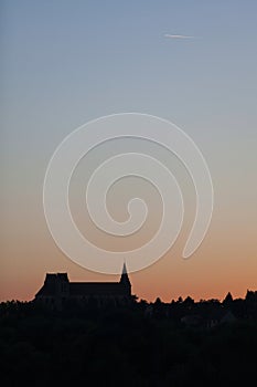 The Church of St. Nicholas in Saint-Leu-d\'Esserent at sunset photo