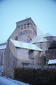 Church stands adjacent to a hedge near a charming building in Saint-Loup-de-Naud