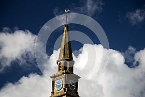 Church Steeple and Clock Against a Blue Cloudy Sky