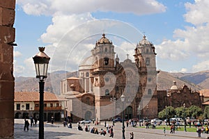 The Church of th e Society of Jesus in the Plaza de Armas in Cusco, Peru with tourists and Peruvians walking through the square