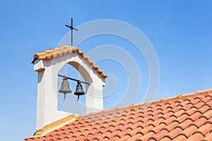 Church tower on roof with bells and cross