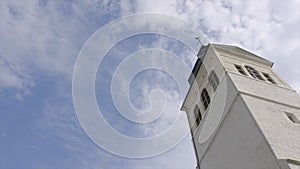 Church tower on a sunny day. Action. White Church steeple on background of blue sky