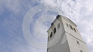 Church tower on a sunny day. Action. White Church steeple on background of blue sky