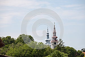 Church towers and steeples of two orthodox churches cohabiting, the Serbian and the romanian one, in Alibunar, Voivodina, Serbia. photo