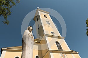 Church of Uznesenja BDM in Cetingrad, Croatia. New church after war in Croatia. Statue of virgin Mary with church tower in backgro