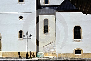 church wall part elevation. stone stair and arched windows. stucco facade. cobblestone road