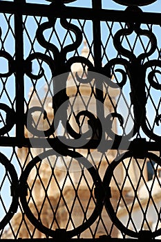 A church through a wrought iron gate, from noto