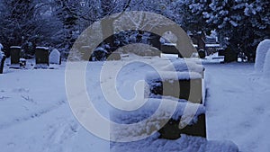 Church yard in on dark winter day with snow falling