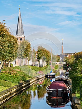 Churchtower, chimney and Eegracht canal in IJlst, Friesland, Netherlands