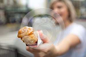 Churro. is a fried-dough pastry snack. With milk sweet tip. Young woman holding sweet