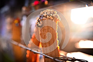 churro stuffed with chocolate and peanuts. In the background there is a beautiful light as a counter light.