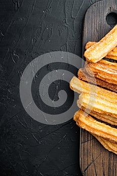 Churros with caramel Traditional Spanish cusine  on black background  top view flat lay with space for text  copyspace