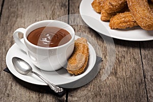 Churros with Chocolate on Wooden Table photo