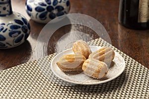 Churros pastry filled with dulce de leche on white plate photo