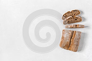 Ciabatta. Dark fresh healthy flattish open-textured Italian bread on white rustic background. Close-up. Top view