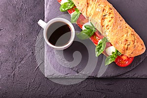 Ciabatta sandwich with caprese salad with coffee.