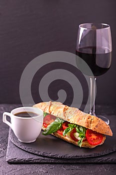 Ciabatta sandwich with caprese salad with wine and coffee.