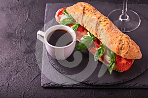 Ciabatta sandwich with caprese salad with wine and coffee.