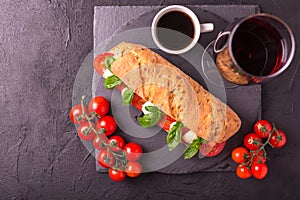 Ciabatta sandwich with caprese salad with wine and coffee.