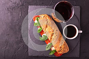 Ciabatta sandwich with caprese salad with wine and coffee.