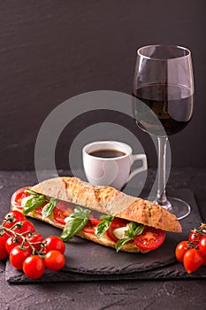 Ciabatta sandwich with caprese salad with wine and coffee.