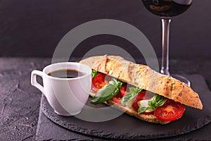 Ciabatta sandwich with caprese salad with wine and coffee.