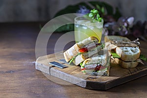 Ciabatta sandwich with turkey, lettuce, tomatoes, cheese on a wooden board