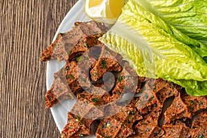 Cig kofte with lettuce and lemon. Turkish local raw food concept
