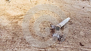 Cigarette butts and cigarette ash lying on the ground