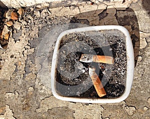 Cigarette ends or butts in an ash tray.