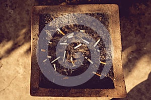 cigarettes and ash on sand in trash tray