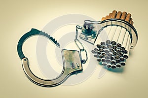 Cigarettes and handcuffs - smoking addiction concept