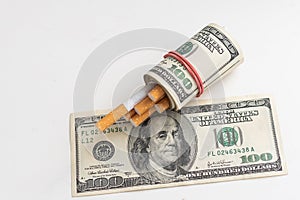Cigarettes on one hundred dollar bill on white background