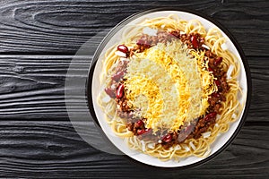 Cincinnati style chili 5 way close up on the black wooden background. Horizontal top view