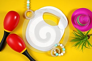 Cinco de Mayo baby bib flatlay on a festive yellow table background