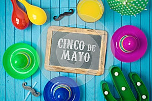 Cinco de Mayo holiday background with chalkboard, Mexican cactus and party sombrero hat on wooden board