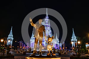 Cinderella Castle, with Christmas icicles behind the statue of Walt Disnsy and Mickey Mouse