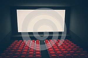 Cinema auditorium with white blank screen and red seats