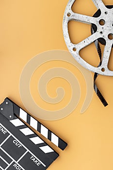 Cinema background with movie clapperboard and film reel