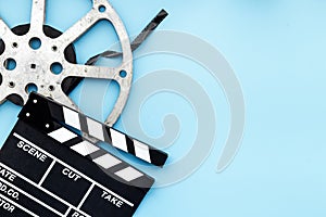 Cinema background with movie clapperboard and film reel