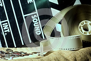 Cinema clapper and video film negative movie on a rough cloth.