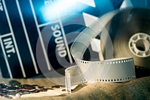 Cinema clapper and video film negative movie on a rough cloth.