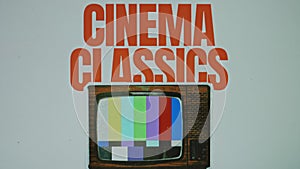 Cinema classics inscription on grey background with image of a vintage TV set, VHS effect on TV. Graphic presentation